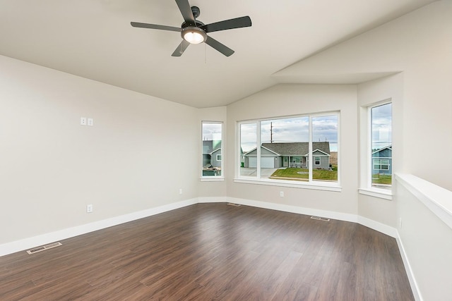 unfurnished room featuring visible vents, dark wood-style floors, vaulted ceiling, and a healthy amount of sunlight