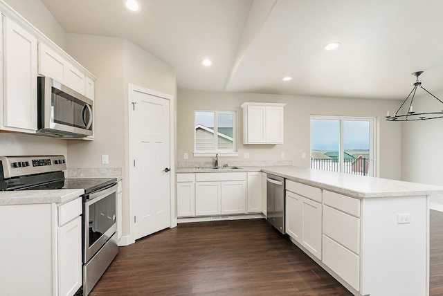 kitchen with stainless steel appliances, a peninsula, a sink, and a healthy amount of sunlight