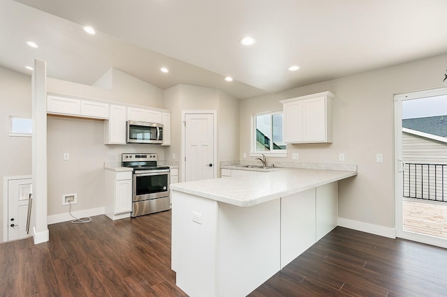 kitchen featuring a peninsula, light countertops, white cabinetry, stainless steel appliances, and a sink