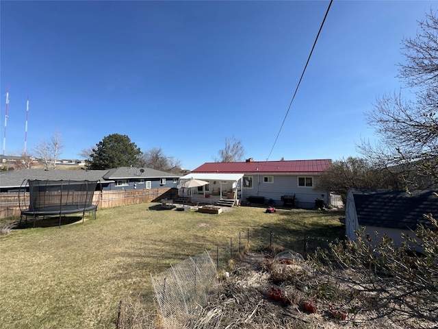 767 33rd Ave NE, Great Falls, MT 59404 - rear view of property featuring a trampoline, a fenced backyard, a shed, and a metal roof