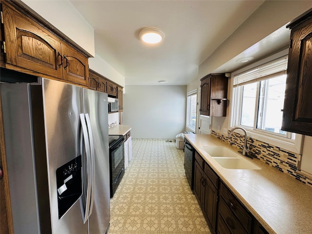 767 33rd Ave NE, Great Falls, MT 59404 - kitchen featuring black appliances, light countertops, backsplash, light floors, and dark brown cabinets