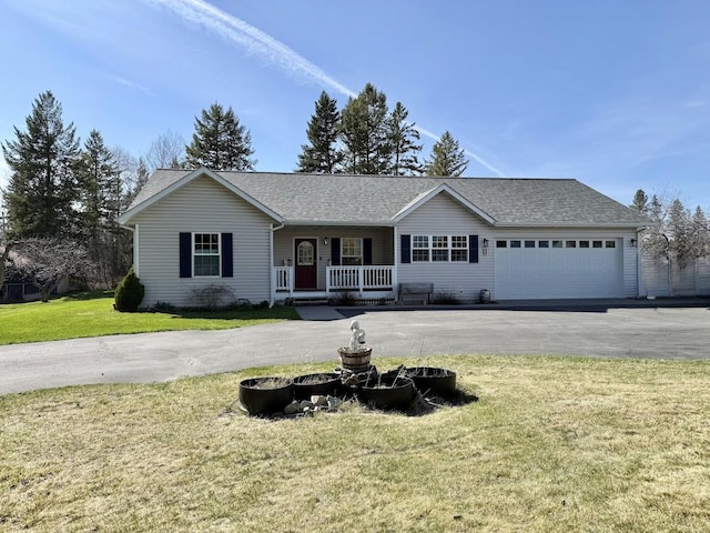 992 Trumble Creek Rd, Kalispell, MT 59901 - single story home featuring covered porch, asphalt driveway, a front lawn, and a garage
