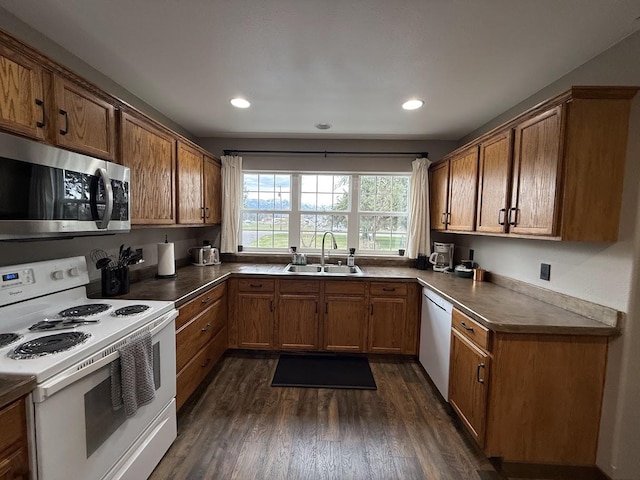 992 Trumble Creek Rd, Kalispell, MT 59901 - kitchen with white appliances, brown cabinetry, dark wood-type flooring, recessed lighting, and dark countertops