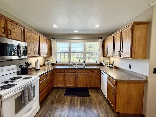 992 Trumble Creek Rd, Kalispell, MT 59901 - kitchen with white appliances, brown cabinets, dark wood-style floors, recessed lighting, and dark countertops
