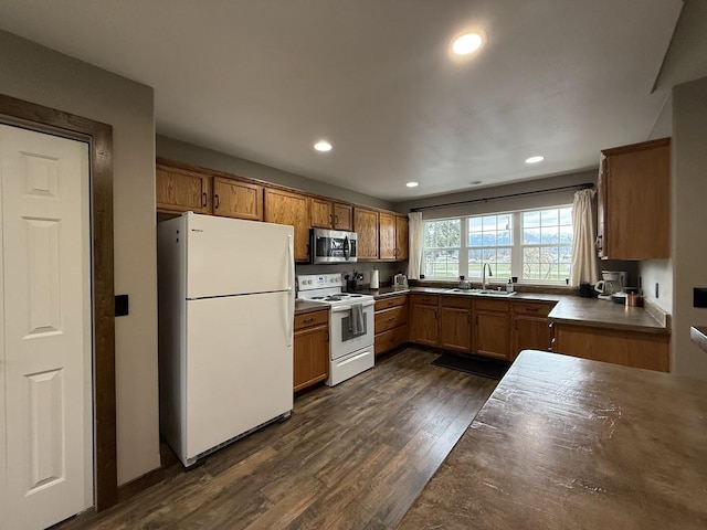 992 Trumble Creek Rd, Kalispell, MT 59901 - kitchen with white appliances, dark wood-style flooring, brown cabinets, recessed lighting, and dark countertops