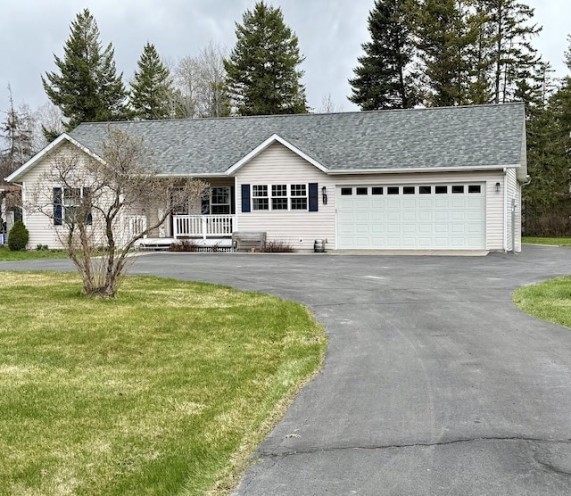 992 Trumble Creek Rd, Kalispell, MT 59901 - single story home with asphalt driveway, a front lawn, a garage, covered porch, and roof with shingles