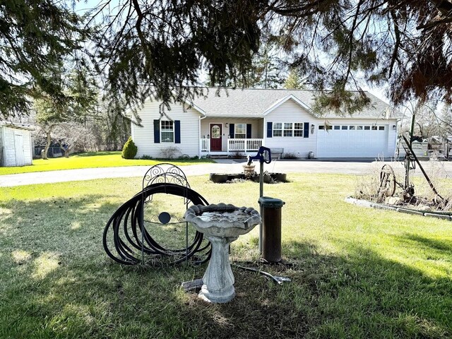 992 Trumble Creek Rd, Kalispell, MT 59901 - ranch-style house with a porch, a front yard, an attached garage, and driveway