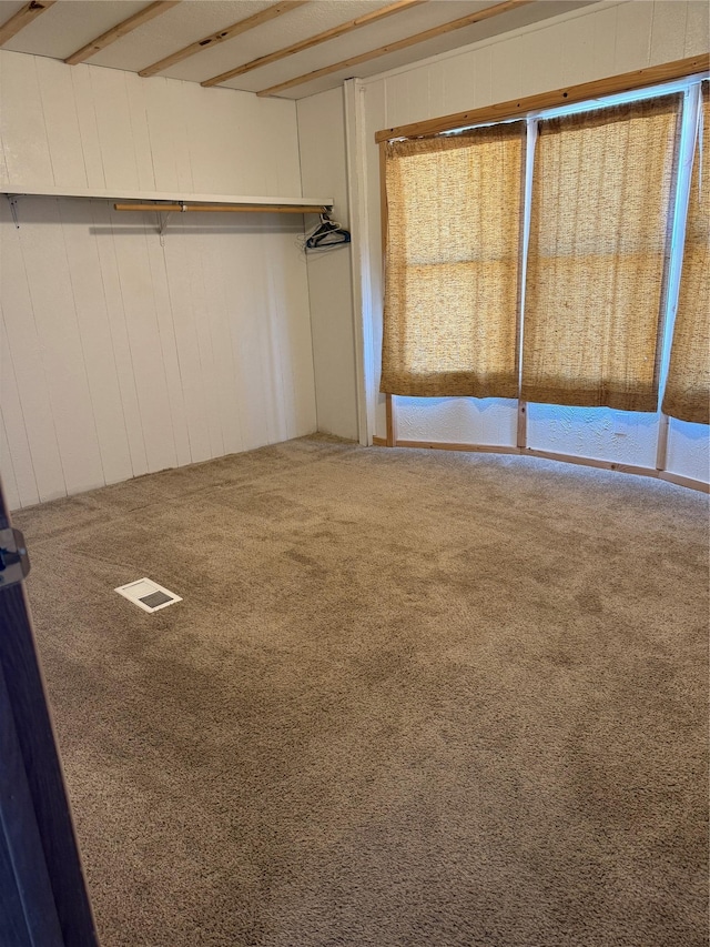 3805 7th St NE Unit 26, Great Falls, MT 59404 - unfurnished bedroom featuring carpet floors, wood walls, and visible vents
