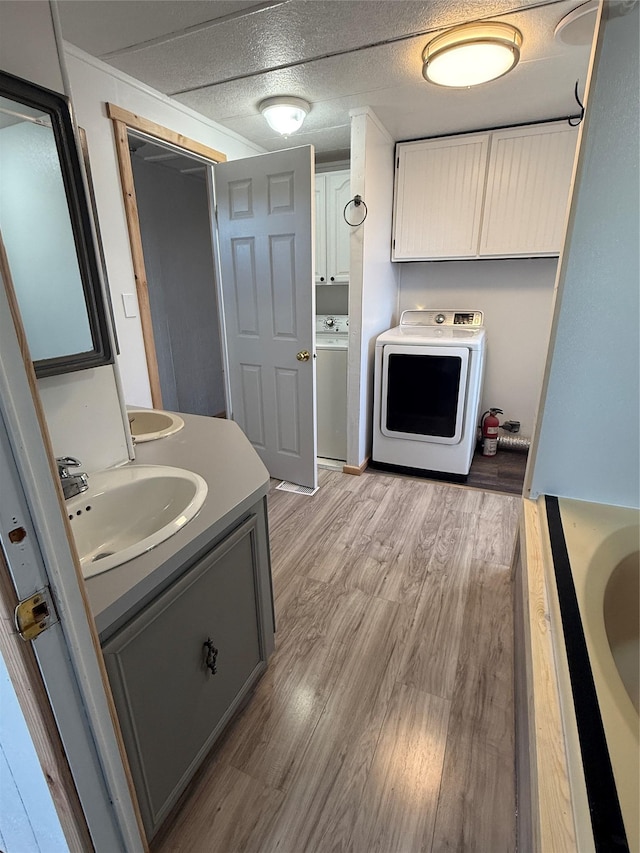 3805 7th St NE Unit 26, Great Falls, MT 59404 - full bathroom featuring washer / clothes dryer, vanity, a bathtub, and wood finished floors