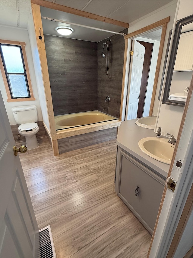 3805 7th St NE Unit 26, Great Falls, MT 59404 - bathroom featuring washtub / shower combination, vanity, toilet, visible vents, and wood finished floors