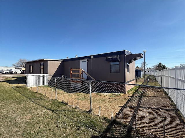 3805 7th St NE Unit 26, Great Falls, MT 59404 - rear view of house featuring fence private yard and a lawn