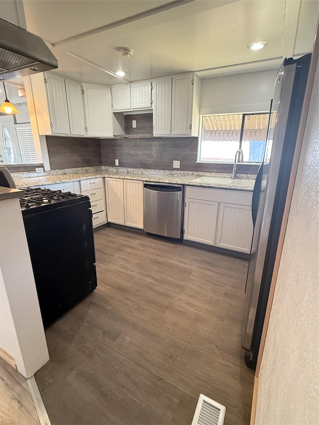 3805 7th St NE Unit 26, Great Falls, MT 59404 - kitchen featuring dark wood-style flooring, a sink, decorative backsplash, appliances with stainless steel finishes, and under cabinet range hood