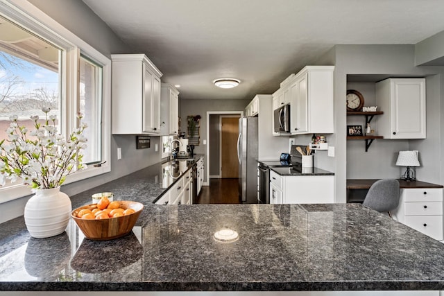 2324 Cloverdale Dr, Missoula, MT 59803 - kitchen with stainless steel appliances, white cabinetry, dark stone countertops, and a desk