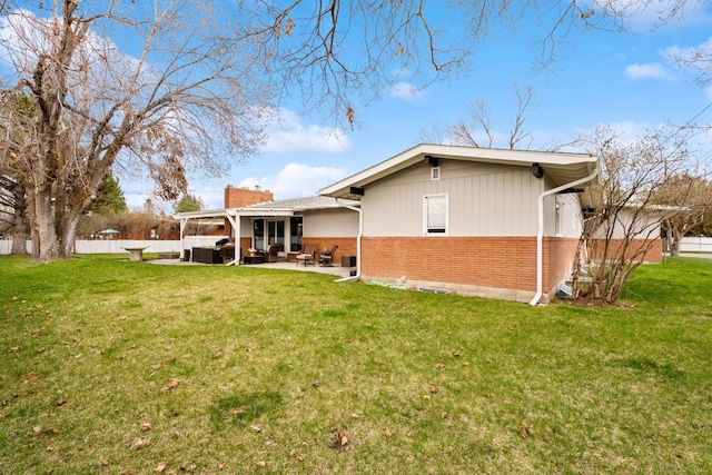 2324 Cloverdale Dr, Missoula, MT 59803 - back of property featuring brick siding, an outdoor living space, a chimney, and a patio area