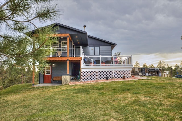back of house with a yard, a wooden deck, and fence