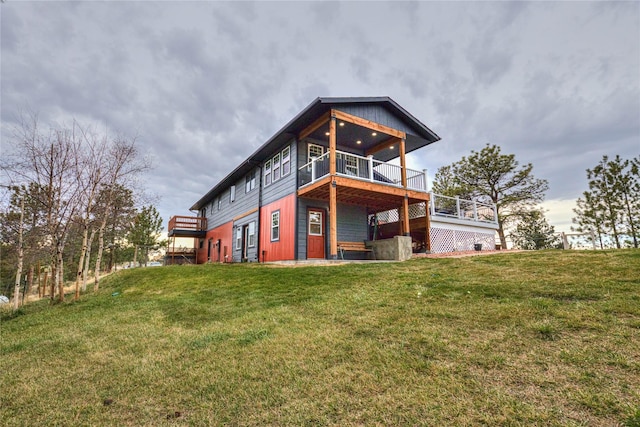 rear view of property featuring a yard and a wooden deck