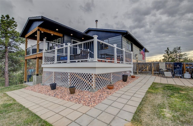 rear view of house with a wooden deck and fence