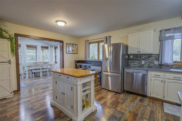 kitchen with white cabinets, open shelves, appliances with stainless steel finishes, dark wood finished floors, and backsplash