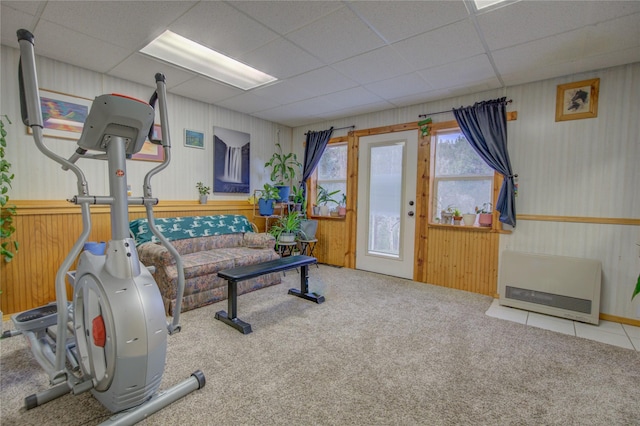 workout room with a paneled ceiling, heating unit, and carpet floors