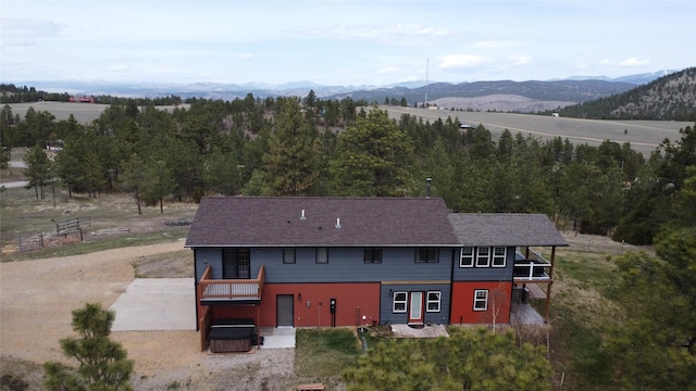 exterior space featuring a jacuzzi, driveway, and a mountain view