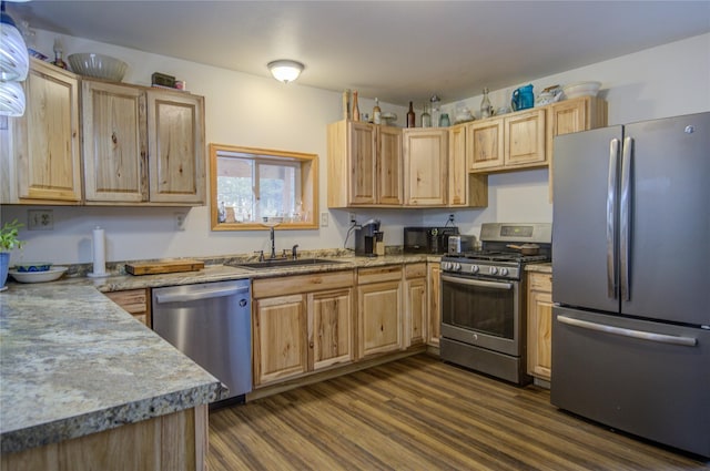kitchen featuring a sink, appliances with stainless steel finishes, light brown cabinets, and dark wood-style floors