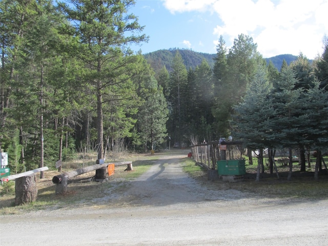64 Ponderosa Ln, Thompson Falls, MT 59873 - view of dirt / gravel road featuring a wooded view and a mountain view