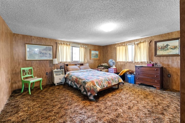 628 Kelley Rd, Columbia Falls, MT 59912 - carpeted bedroom featuring a textured ceiling, multiple windows, and wooden walls