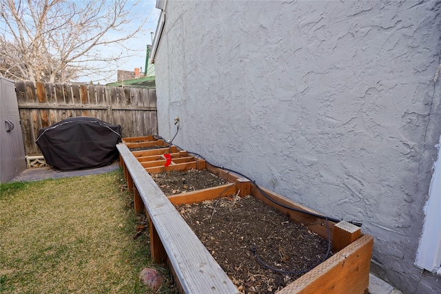 view of home's exterior with a garden, stucco siding, and fence