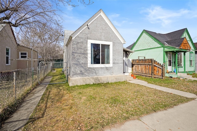 view of front of house featuring a front yard, stucco siding, and fence
