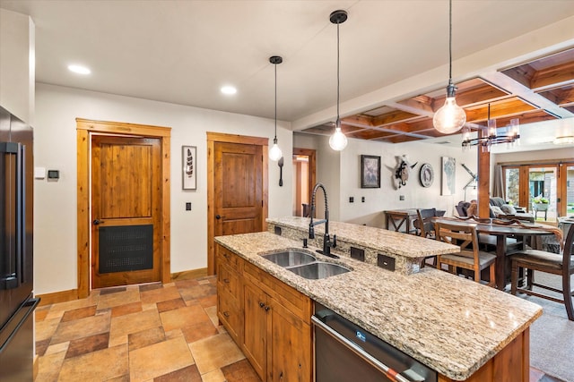 kitchen with pendant lighting, a sink, baseboards, dishwasher, and a center island with sink