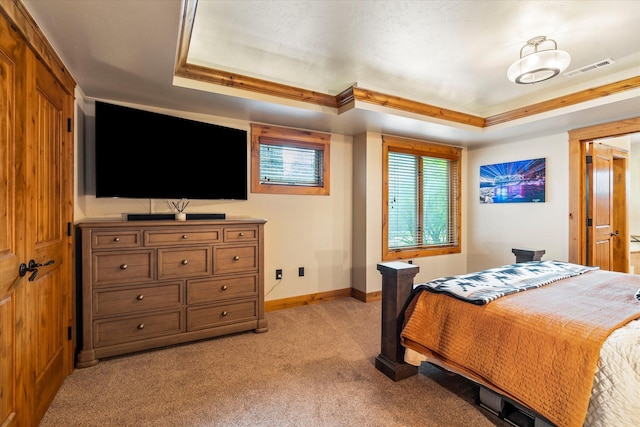 bedroom with visible vents, light carpet, baseboards, and a tray ceiling