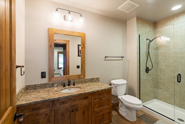 full bathroom featuring visible vents, a stall shower, toilet, and vanity