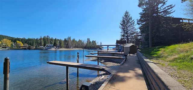 view of dock with a forest view and a water view