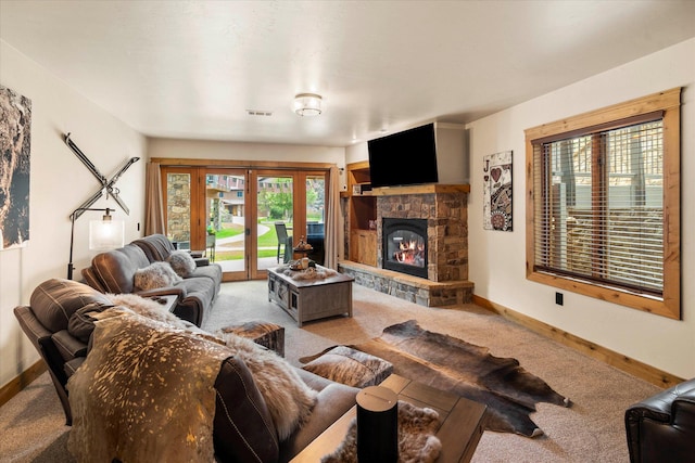carpeted living room featuring baseboards, visible vents, french doors, and a fireplace