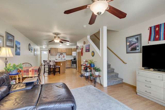 1923 Montana St Unit B, Missoula, MT 59801 - living room with light wood-style flooring, ceiling fan, baseboards, and stairs