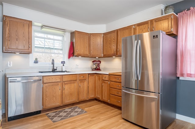 1634 W Central Ave, Missoula, MT 59801 - kitchen featuring stainless steel appliances, a sink, light countertops, light wood-style flooring, and brown cabinets