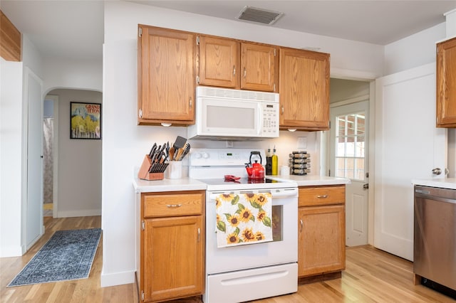 1634 W Central Ave, Missoula, MT 59801 - kitchen featuring white appliances, light wood-type flooring, light countertops, and arched walkways