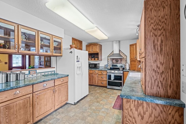 538 Bighorn Dr, Thompson Falls, MT 59873 - kitchen with wall chimney range hood, black microwave, white refrigerator with ice dispenser, brown cabinets, and double oven range