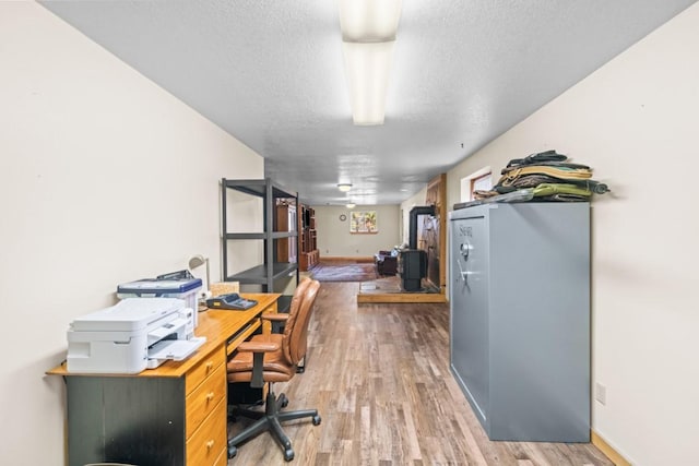 538 Bighorn Dr, Thompson Falls, MT 59873 - office area with a wood stove, baseboards, wood finished floors, and a textured ceiling