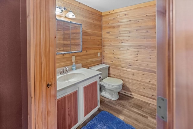538 Bighorn Dr, Thompson Falls, MT 59873 - half bath featuring toilet, wood finished floors, vanity, and wooden walls