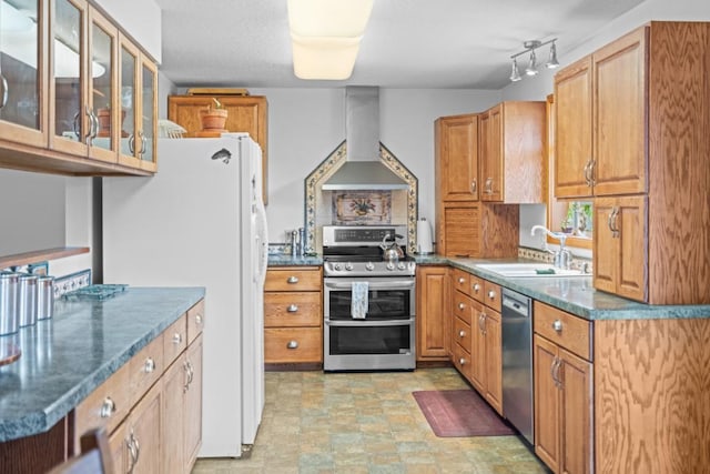 538 Bighorn Dr, Thompson Falls, MT 59873 - kitchen with wall chimney exhaust hood, glass insert cabinets, brown cabinetry, a sink, and stainless steel appliances