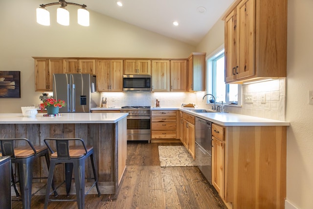 716 Shadow Dancer Way, Stevensville, MT 59870 - kitchen with stainless steel appliances, dark wood-type flooring, light countertops, a kitchen bar, and recessed lighting