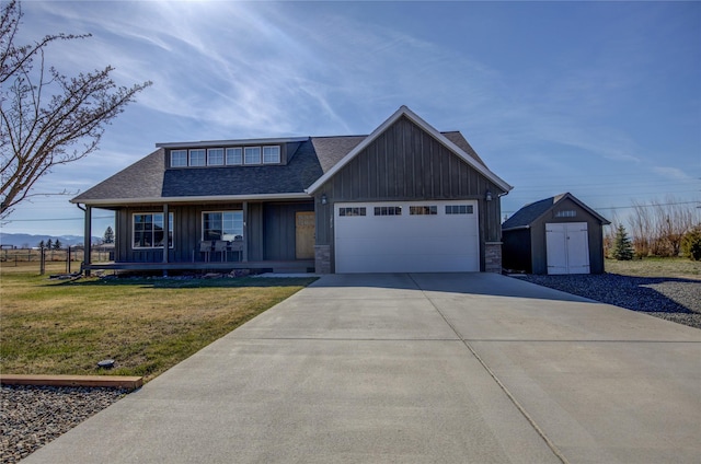3774 Juliet Dr, Helena, MT 59602 - view of front facade featuring board and batten siding, a storage unit, a garage, driveway, and roof with shingles