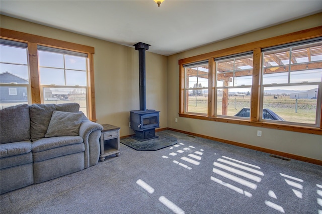 3774 Juliet Dr, Helena, MT 59602 - carpeted living area featuring baseboards, a wood stove, and visible vents