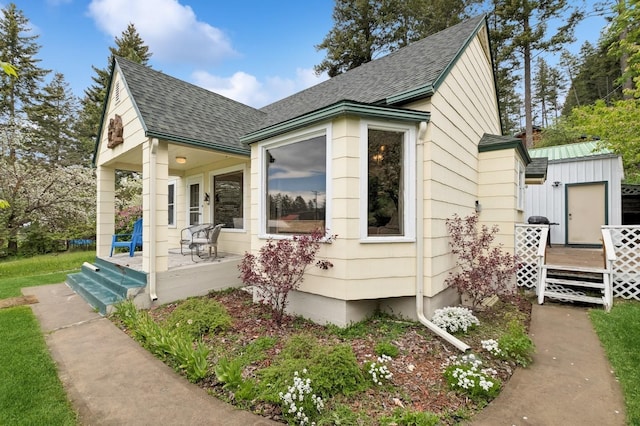 14668 Shore Acres Dr, Bigfork, MT 59911 - view of home's exterior with covered porch, roof with shingles, and a deck