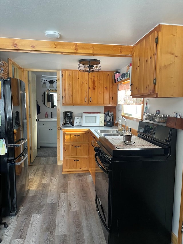 3806 Mt Highway 83 Unit 2, Seeley Lake, MT 59868 - kitchen with black appliances, wood finished floors, and beamed ceiling