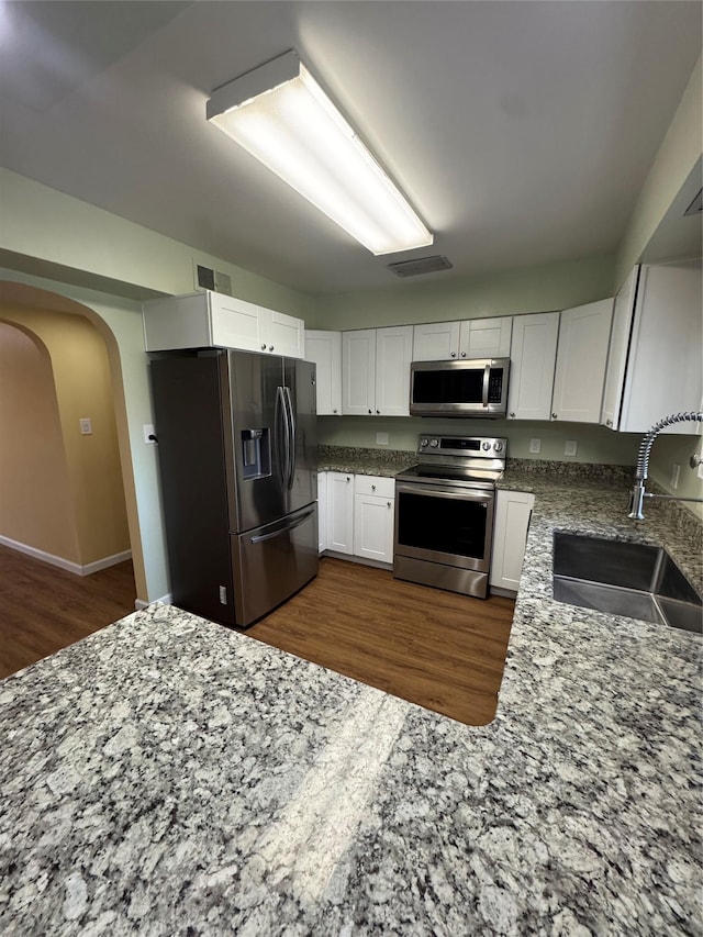 kitchen featuring a sink, visible vents, white cabinets, and stainless steel appliances