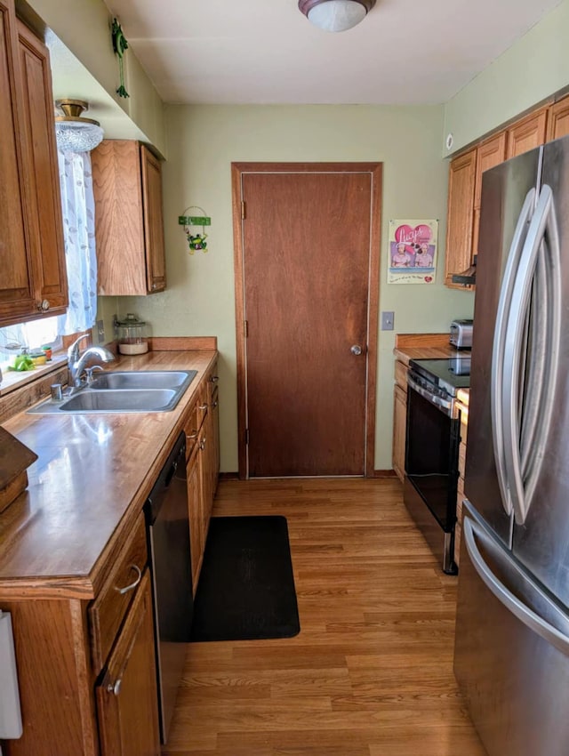 2599 Pike Dr, East Helena, MT 59635 - kitchen with brown cabinetry, light wood-style floors, a sink, and stainless steel appliances