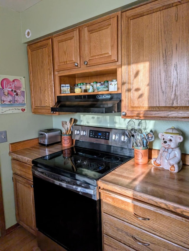 2599 Pike Dr, East Helena, MT 59635 - kitchen with open shelves, wooden counters, under cabinet range hood, brown cabinets, and electric range