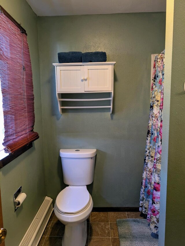 2599 Pike Dr, East Helena, MT 59635 - bathroom with tile patterned floors, curtained shower, a baseboard radiator, and toilet